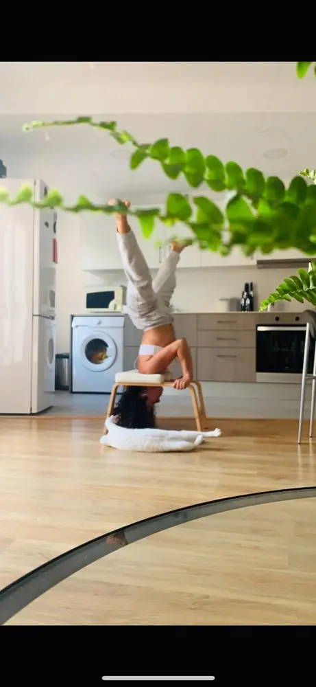 Eli in a headstand at home among plants